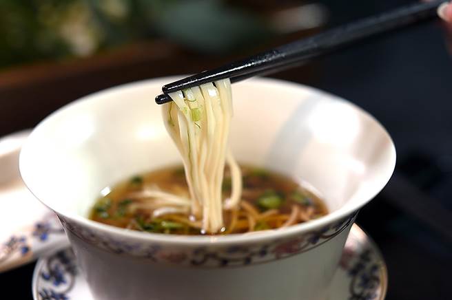 〈impromptu〉新菜〈鸡汤麵〉，汤是西式手法烹制的澄清鸡汤，麵条则是仿陕西传统麵食〈乾州鸡麵〉，用鸡肉蓉混合淀粉制作，汤汁清鲜、麵条口感似干丝。（图／姚舜）