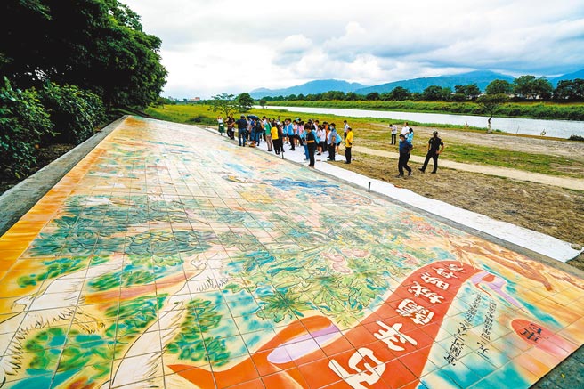宜兰版清明上河图坐落在宜兰河庆和桥下南岸边坡，陶雕壁画由6510片陶板组成，宜兰县长林姿妙与宜兰高中美术班学生一起为壁画嵌入琉璃珠。（李忠一摄）