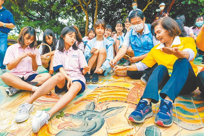 宜兰版清明上河图坐落在宜兰河庆和桥下南岸边坡，陶雕壁画由6510片陶板组成，宜兰县长林姿妙（右一）与宜兰高中美术班学生一起为壁画嵌入琉璃珠。（李忠一摄）