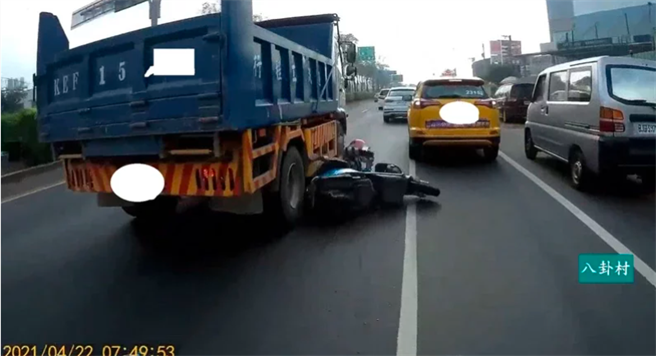 女骑士疑似想超车而变换车道，结果遭左后方砂石车擦撞，当场摔车在大车轮旁险爆头，画面惊悚。（图／摘自脸书《八卦村 - 行车纪录器影片上传中心》）