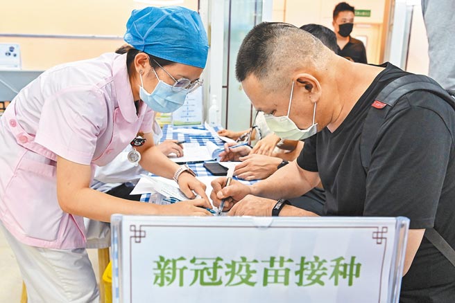 大陸首支mRNA疫苗亮相。圖為22日在廣州的台灣人登記接種新冠疫苗。（中新社）