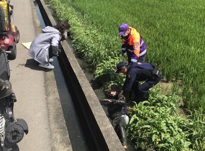 一名老翁不慎摔到田邊，兩名員警將老翁救起並協助清潔。（龍潭分局提供／邱立雅桃園傳真）