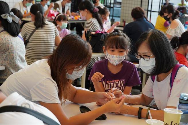 高雄市立社会教育馆24日举办「幸运草串珠DIY」活动，吸引不少亲子体验串珠富涵逻辑及空间概念的乐趣。（高市社教馆提供／袁庭尧高雄传真）