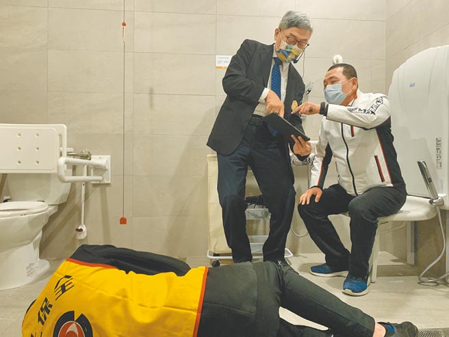 公共托老中心向侯友宜演示浴厕防跌侦测装置。（王扬杰摄）