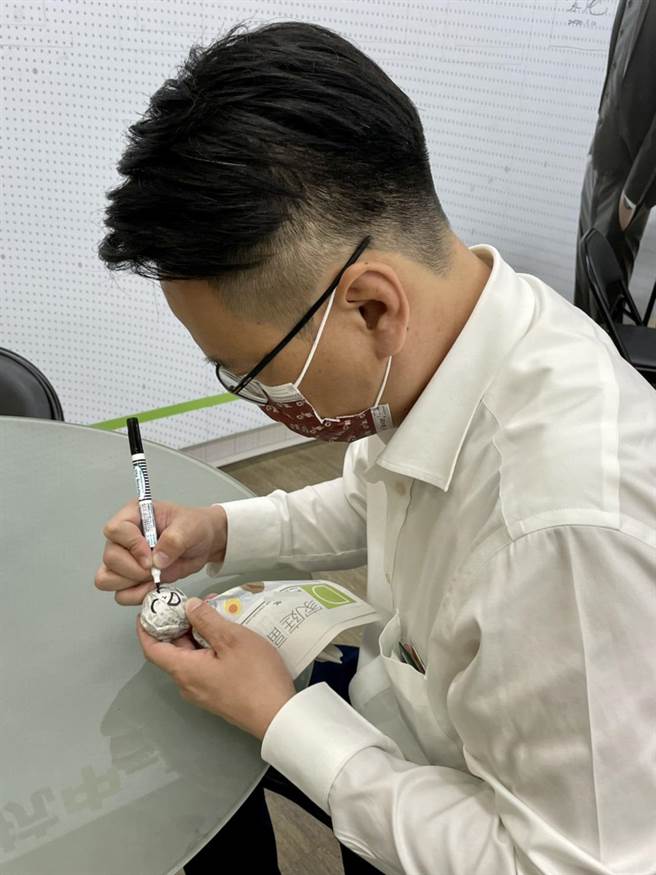 立委庄竞程以古老传说的雨天娃娃，DIY两个雨天娃娃，挂在服务处门沿。（卢金足摄）