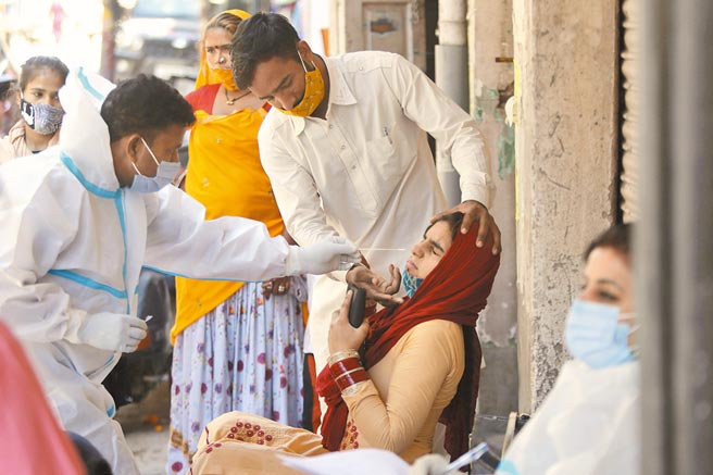 印度疫情急速惡化，新冠患者暴增，病床、醫用氧氣和藥品等供應吃緊，圖為醫護人員就地檢驗新冠病毒。 （美聯社）