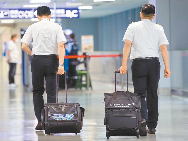 对于指挥中心批华航疫苗接种太慢，华航企业工会表示，「机组员不是反对，而是担心配套不足」。图为桃园机场2名机师正准备通关入境。（图中非当事人）（范扬光摄）