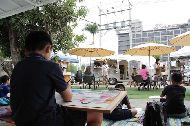 参赛小朋友聚在咖啡车前写生，虽飘着细雨，现场气氛仍不亦乐乎。图双福基金会提供