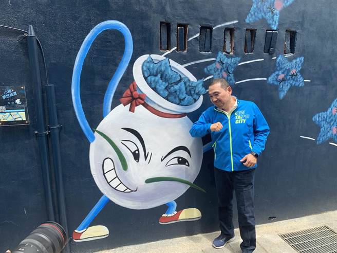 新北市長侯友宜在彩繪牆前和繪本中的角色互動。（王揚傑攝）