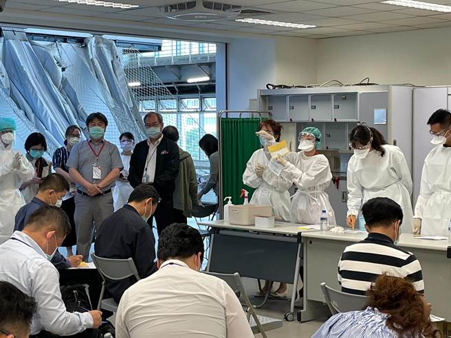 衛福部醫福會執行長王必勝在中華航空總經理高星潢陪同下視察機組員疫苗施打狀況。（華航提供）