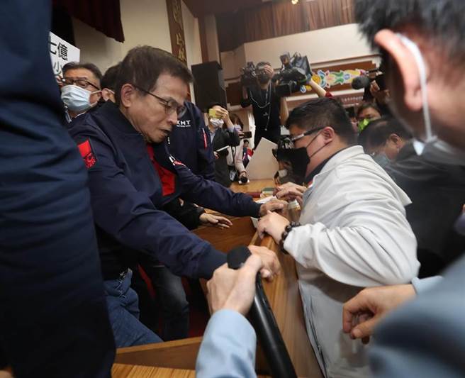 立法院财政委员会28日审查《会计法》第99-1条修正草案等，国民党立委质疑该案有意替前总统陈水扁的国务机要费除罪化，国民党团总召费鸿泰、立委赖士葆（左）等人举标语、发言杯葛并要求散会，不该处理法案，赖士葆拉扯麦克风并要推倒议事桌，而绿委蔡易余（右）等则试图阻止，蓝、绿双方发生口角及肢体拉扯，礼券、标语及麦克风散落一地，现场一片混乱。（刘宗龙摄）