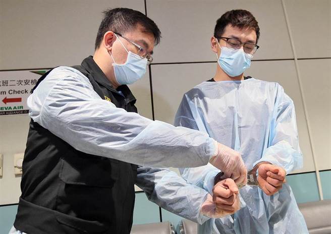 台北市信义区夜店杀警案震惊社会，潜逃出境的嫌犯许淳凯（右）28日下午由刑事局干员从马来西亚押解回台，下机后员警立刻上前戴上手铐。（范扬光摄）
