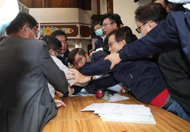 立法院财政委员会28日审查《会计法》第99-1条修正草案等，国民党立委质疑该案有意替前总统陈水扁的国务机要费除罪化，国民党团总召费鸿泰、立委赖士葆（右二）等人举标语、发言杯葛并要求散会，不该处理法案，赖士葆拉扯麦克风并要推倒议事桌，而绿委蔡易余（左二）等则试图阻止，蓝、绿双方发生口角及肢体拉扯，礼券、标语及麦克风散落一地，现场一片混乱。（刘宗龙摄）