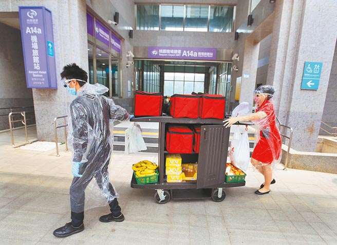 桃园医院防疫团队27日起在华航园区设置临时医疗站，2名身穿防护装备的饭店员工，27日送餐至华航园区内的机场防疫旅馆。（范扬光摄）
