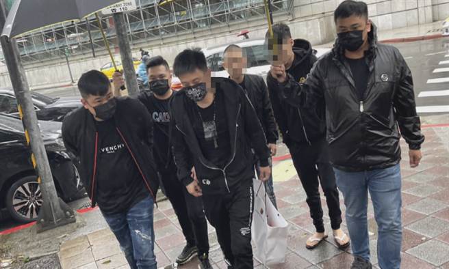 涉嫌媽祖文化協會槍擊案主嫌綽號楊鷲（手提白色紙袋、中）與大郭（左側）今天上午7點多主動投案，警方依違反槍砲彈刀條例送辦。（圖：李文正翻攝）