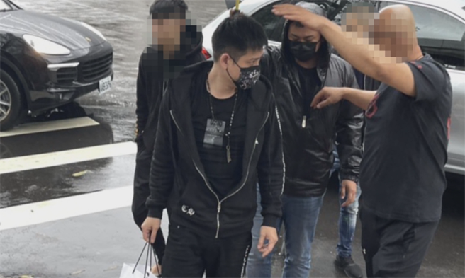 赵介佑仇家投案排场超狂，搭名车还有13小弟撑伞护送进警局。(李文正翻摄)