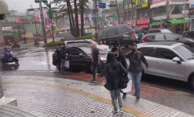 赵介佑仇家投案排场超狂，搭名车还有13小弟撑伞护送进警局。(李文正翻摄)