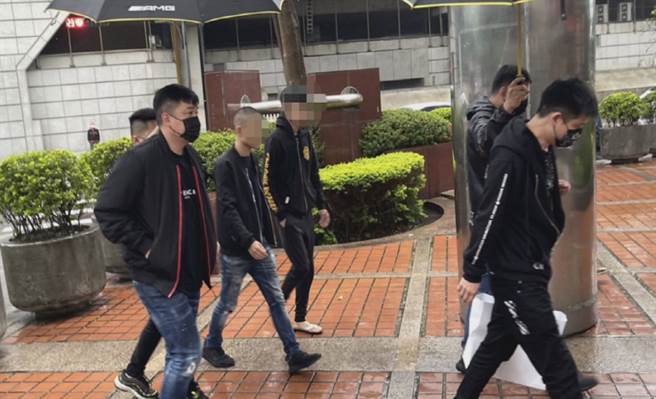 赵介佑仇家投案排场超狂，搭名车还有13小弟撑伞护送进警局。(李文正翻摄)