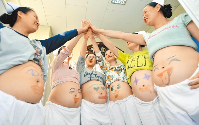 如何促进生育是大陆头号任务。在山西省人民医院，神经外科的准妈妈护士们展示画上笑脸的肚子。（新华社）