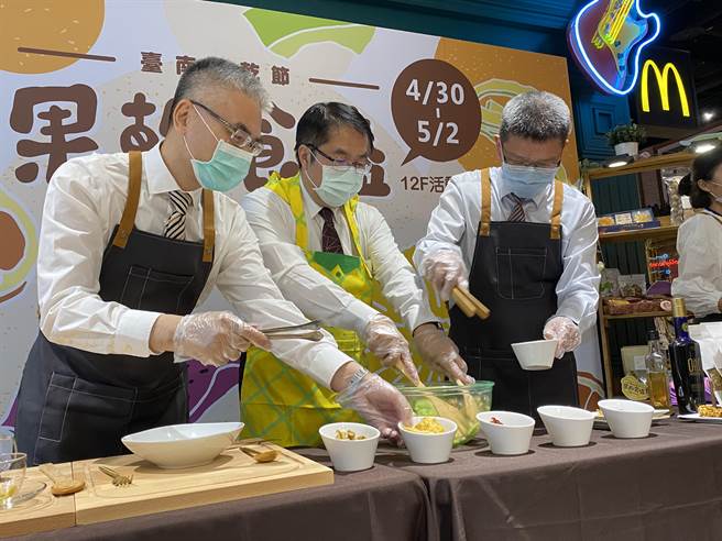 台南市长黄伟哲（中）与中大远百店长蓝卓成（右）、台南市农业局长谢耀清，一起穿上围裙，在百货卖场里示范果乾沙拉。（冯惠宜摄）