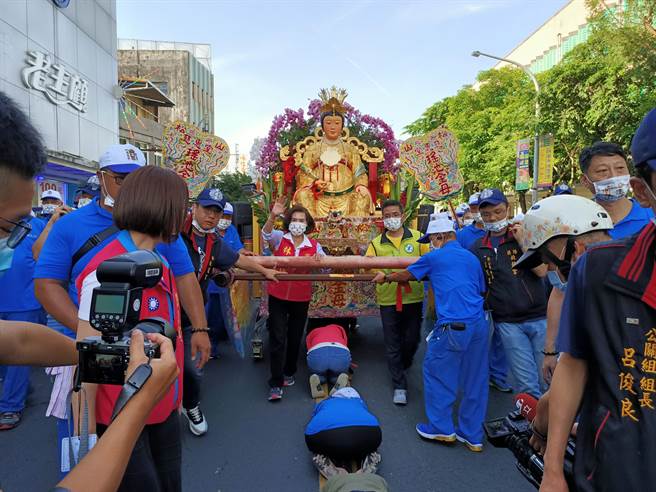 宜兰县长林姿妙与宜兰市长江聪渊一起推着瑶池金母的峦轿缓慢前进，帮民眾完成「钻轿底」 仪式。（胡健森摄）