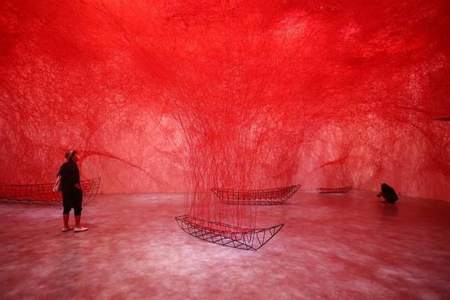 塩田千春《集聚—找寻目的地》以红线和行李箱表现出走与回归的心境。（邓博仁摄）