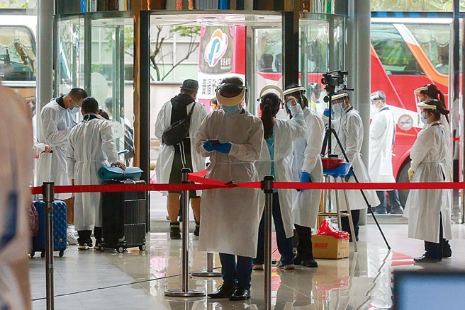 华航机组人员检疫居住的诺富特华航桃机饭店主管确诊新冠肺炎，目前在加护病房治疗，29日饭店开始清空作业，共撤离412人至集中检疫所。工作人员全副武装穿上防护衣帽，安排住客搭乘游览车到集中检疫所。（陈麒全摄）