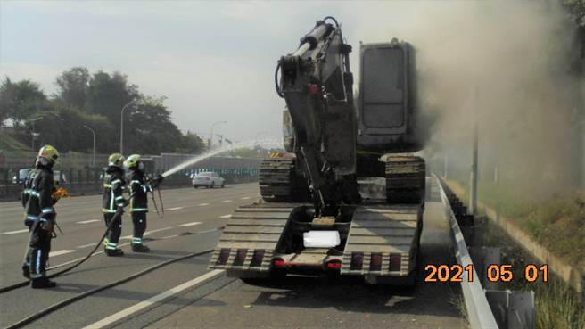 一部曳引车载运怪手，1日上午7时44分许，于国道1号南向363.4公里鼎金路段起火，消防人员到场抢救。（翻摄照片／林瑞益高雄传真）