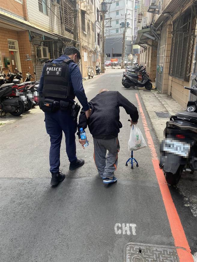 中坜警方发现老人蹲坐在路边，急协助返家。（中坜分局提供）