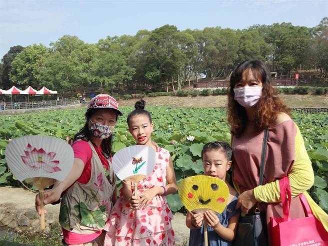 大朋友带着小朋友在现场写生，将莲花的美丽姿态纪录在纸上。（张毓翎摄）