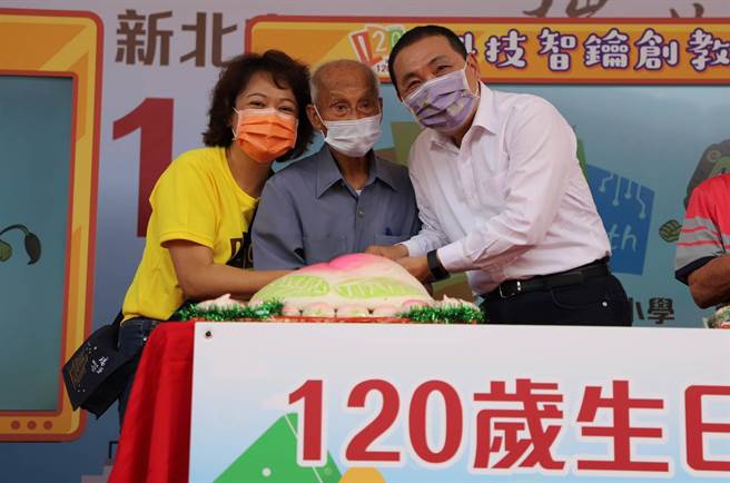 94岁李春长一家四代都是瑞芳国小学生，今与新北市长侯友宜一齐切蛋糕为学校120周年校庆送上祝福。（许哲瑗摄）