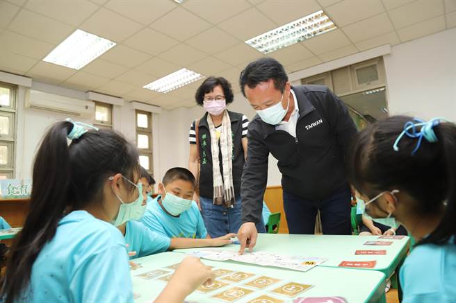 嘉义县长翁章梁（后排右一）在揭牌后参观资源中心内的展示并聆听学生及青农的导览与分享。（张亦惠摄）