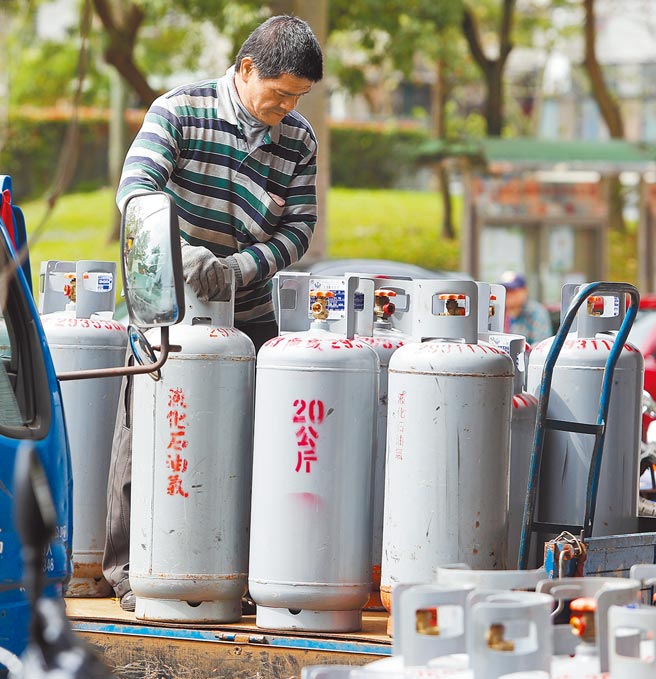 图为瓦斯行员工正将桶装瓦斯从车上搬移到储藏室。（本报资料照片）