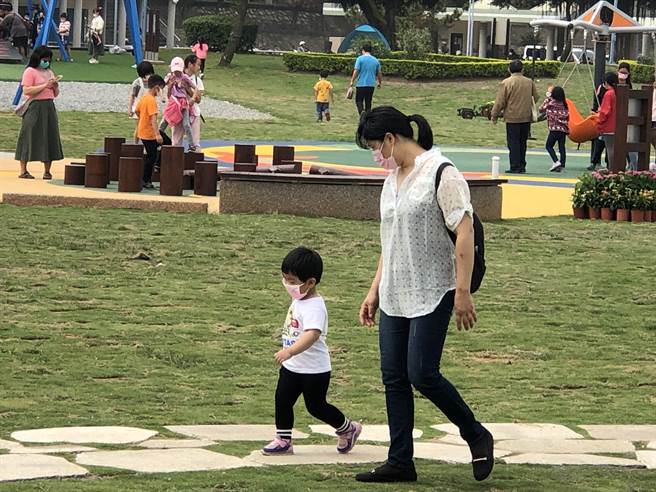 一位妈妈带着小朋友走在园区，亲子同乐共度愉快假日。（李金生摄）
