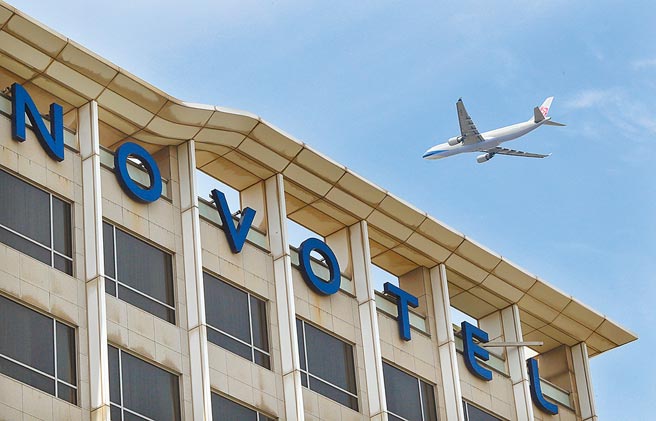 1架华航班机1日飞越诺富特饭店上空。（范扬光摄）