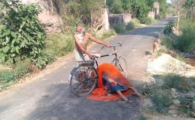 一位印度老人的妻子因染疫过世，村民怕被感染不让他就地火化，老人遭到驱赶后用自行车载着亡妻尸体四处寻找火葬场，场面令人鼻酸。（图／网路）