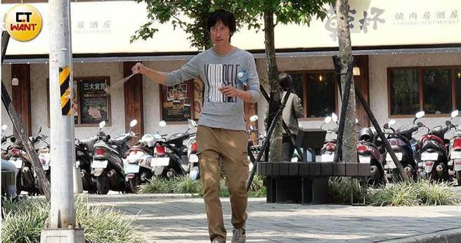 穿着轻便的唐治平，腋下挟着水瓶，右手甩着佛牌，悠哉地在公园閒晃。（图／本刊摄影组）