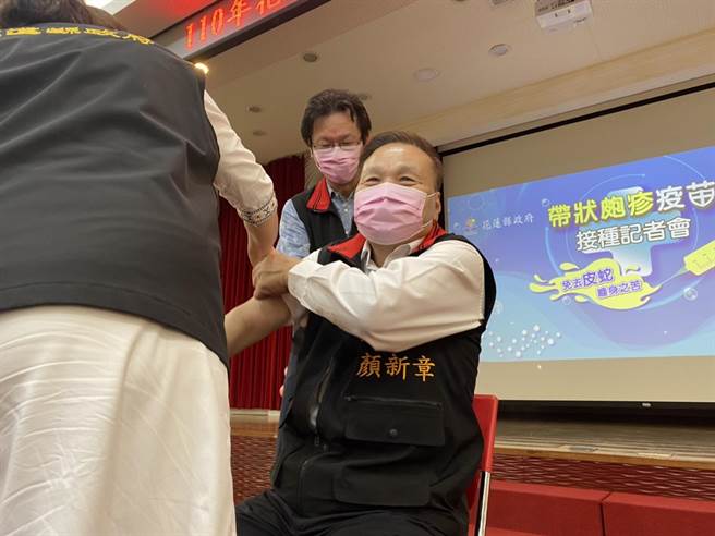 花莲县长徐榛蔚担任起副县长顏新章的女儿，帮他卷起衣袖，方便他接种带状疱疹疫苗。（罗亦晽摄）
