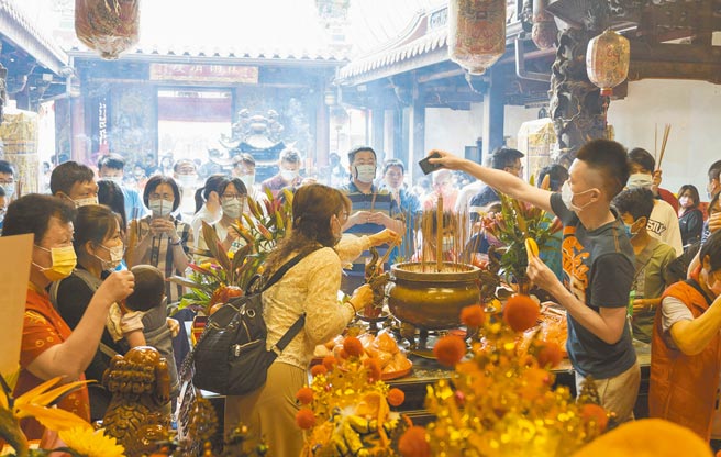 台中市南屯区万和宫妈祖契子女回宫，换上红纱线在香炉过火，祈求新的一年平安、健康。（陈世宗摄）