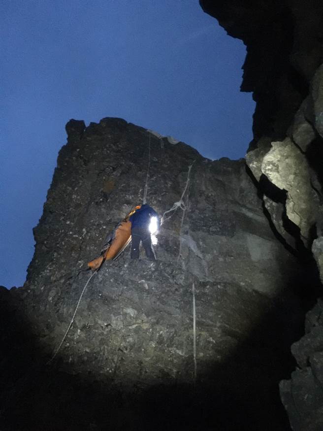 山搜人员使用绳索器材架设拖拉系统将徐男大  体运送至品田山三角点。（新竹县消防局提供／罗浚滨新竹传真）