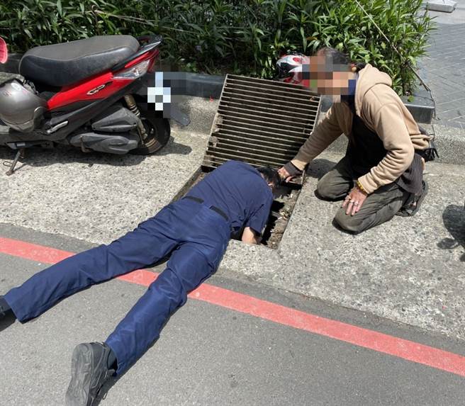 民眾祖傳戒指掉水溝，熱心派出所長用通槍條趴路面取回。(警方提供)