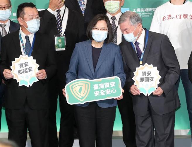 蔡英文总统（中）4日出席「2021臺湾资安大会开幕典礼」率领政府官员与参展的厂商合影留念，与行政院副院长沈荣津（右）互相交换意见，图左为国安会秘书长顾立雄。（郑任南摄）
