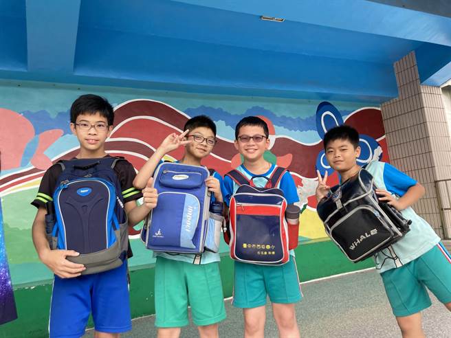 台中市西屯国小学生以前背书包方式，体验妈妈怀孕负重的辛苦。（卢金足摄）