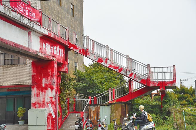 彰化市国圣国小位前的人行陆桥已有40年桥龄，桥面多处严重破损裸露、铺面隆起，彰化市公所进行桥梁结构安全性补强工程，预计暑假前夕就能完工。（谢琼云摄）