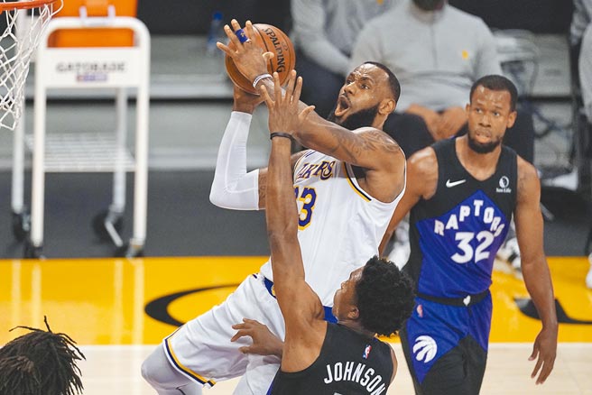 湖人前锋詹姆斯持球强攻禁区，遭到暴龙前锋史坦利强生的打手犯规。（美联社）