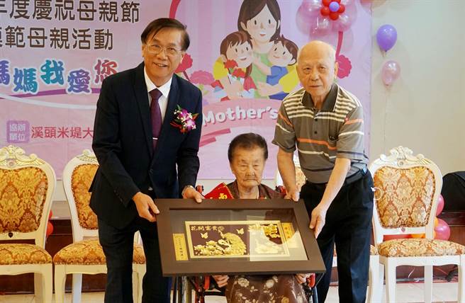 南投县府，5日举行庆祝母亲节暨表扬模范母亲活动，南投县长林明溱（左）颁发「母仪典范」贺匾给15位模范母亲，图为高龄107岁的廖王荫女士，为15位模范母亲中最高龄。（黄国峰摄）