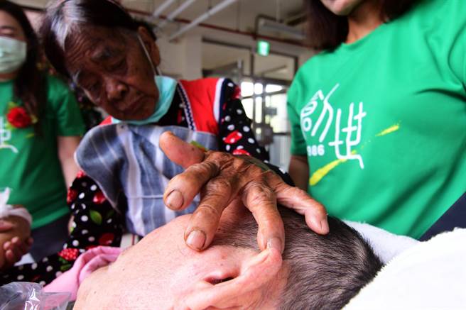 88岁的兰屿妈妈今天 到创世探望久违的植物人儿子，满布风霜皱纹的手，不时抚触着沉睡6年的爱儿。（庄哲权摄）