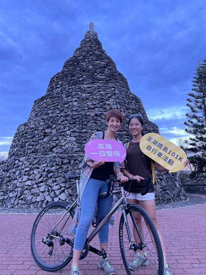 铁人美女主播夏嘉璐（左）、侯以理（右）解锁澎湖跳岛101Ｋ一日双塔，于锁港北塔前合影留念。（大会提供）