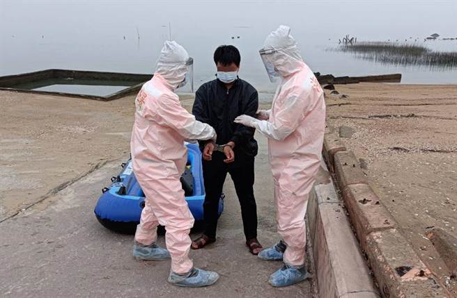 海巡人员早就全副武装穿好隔离装备等着偷渡客上岸。（海巡署提供）