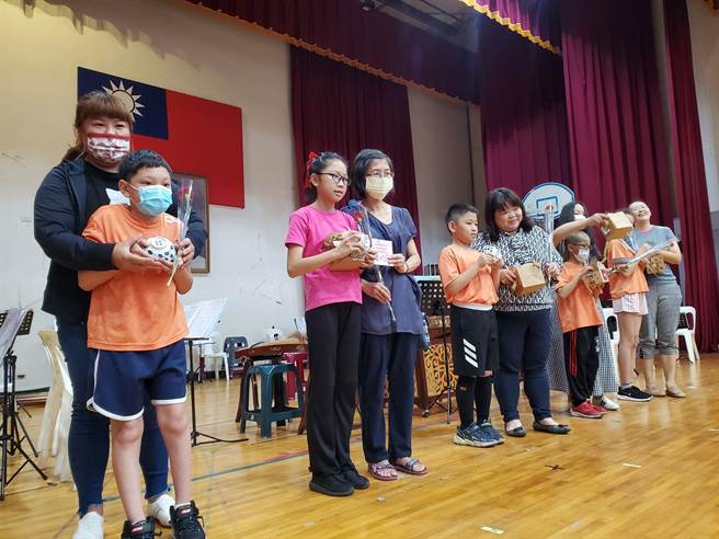 五年级小朋友林洧聪（左二）罹患脑麻症，他和助理老师一起装饰提袋，林妈妈（左一）6日特地到校接受儿子爱的礼物。（周丽兰摄）